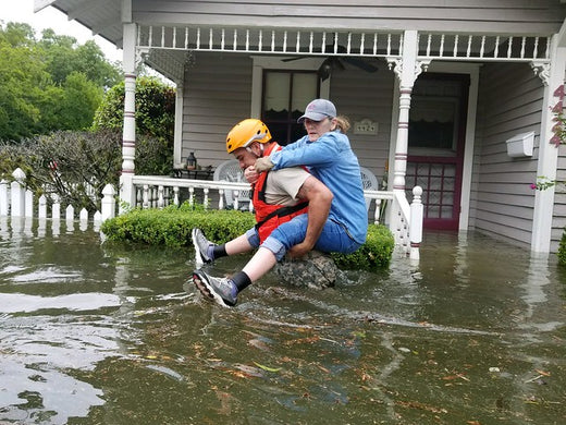 rescue worker careers woman out of flood