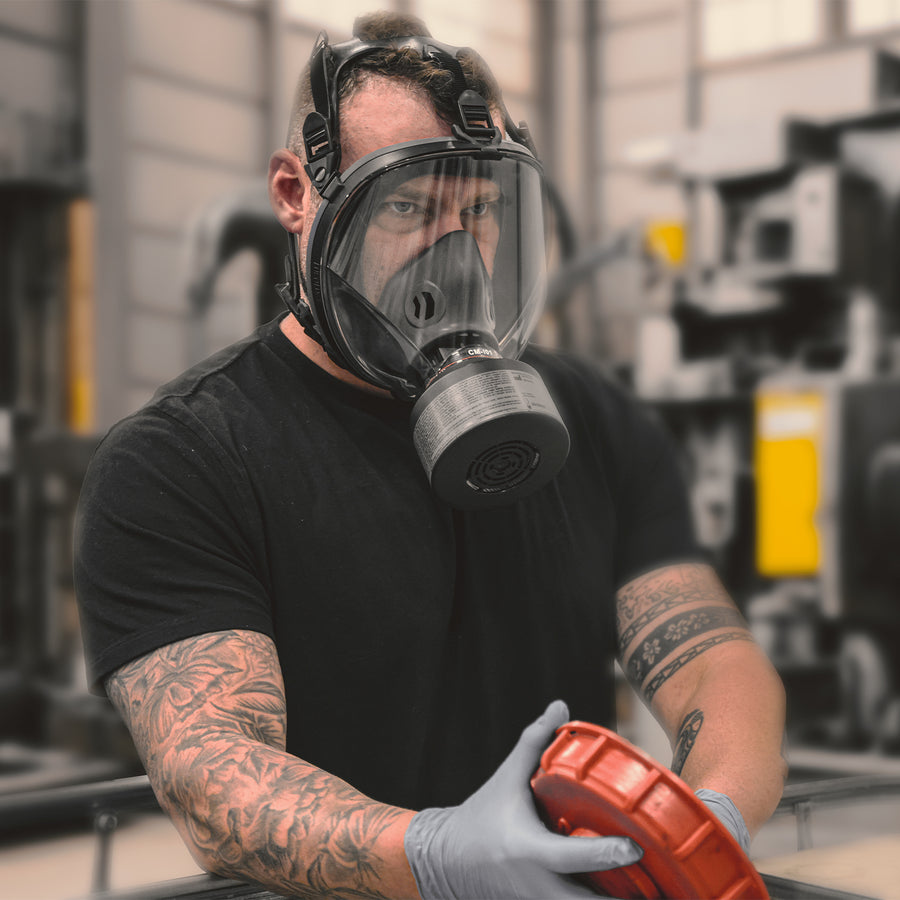 Man cleaning out a container lid with gloves on, wearing a CM-I01 respirator.